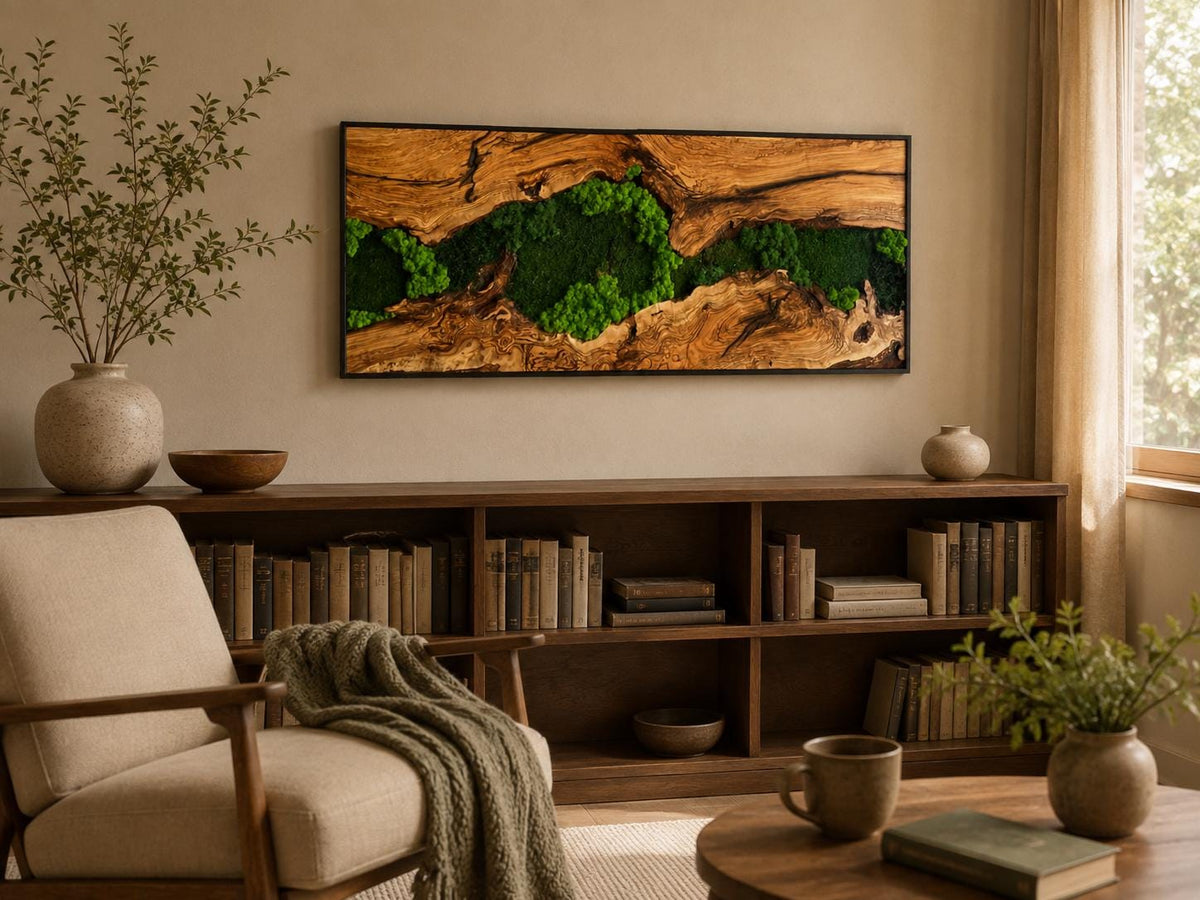 A rectangular wall art piece featuring a natural wood slab with a prominent grain and a central crevice filled with vibrant green preserved moss, all enclosed within a thin black frame mounted horizontally on a plain wall.