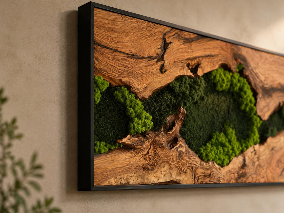 A rectangular wall art piece featuring a natural wood slab with a prominent grain and dark knots, framed in a thin black border. The center of the wood is filled with clusters of vibrant, textured green preserved moss.