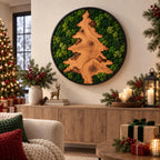 A circular wall art piece featuring a natural wood slice shaped like a pine tree, surrounded by preserved green moss within a black frame. The wood displays visible grain, knots, and textured bark edges, creating a contrast with the moss.