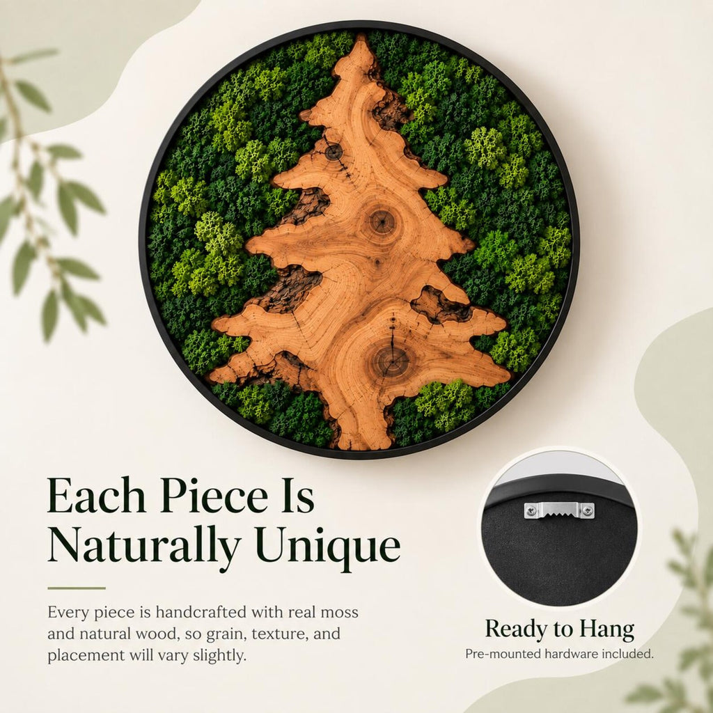 A circular wall art piece featuring a light brown wood slice shaped like a pine tree, surrounded by preserved green moss within a black frame. The back of the frame includes a metal sawtooth hanger for mounting on a wall.