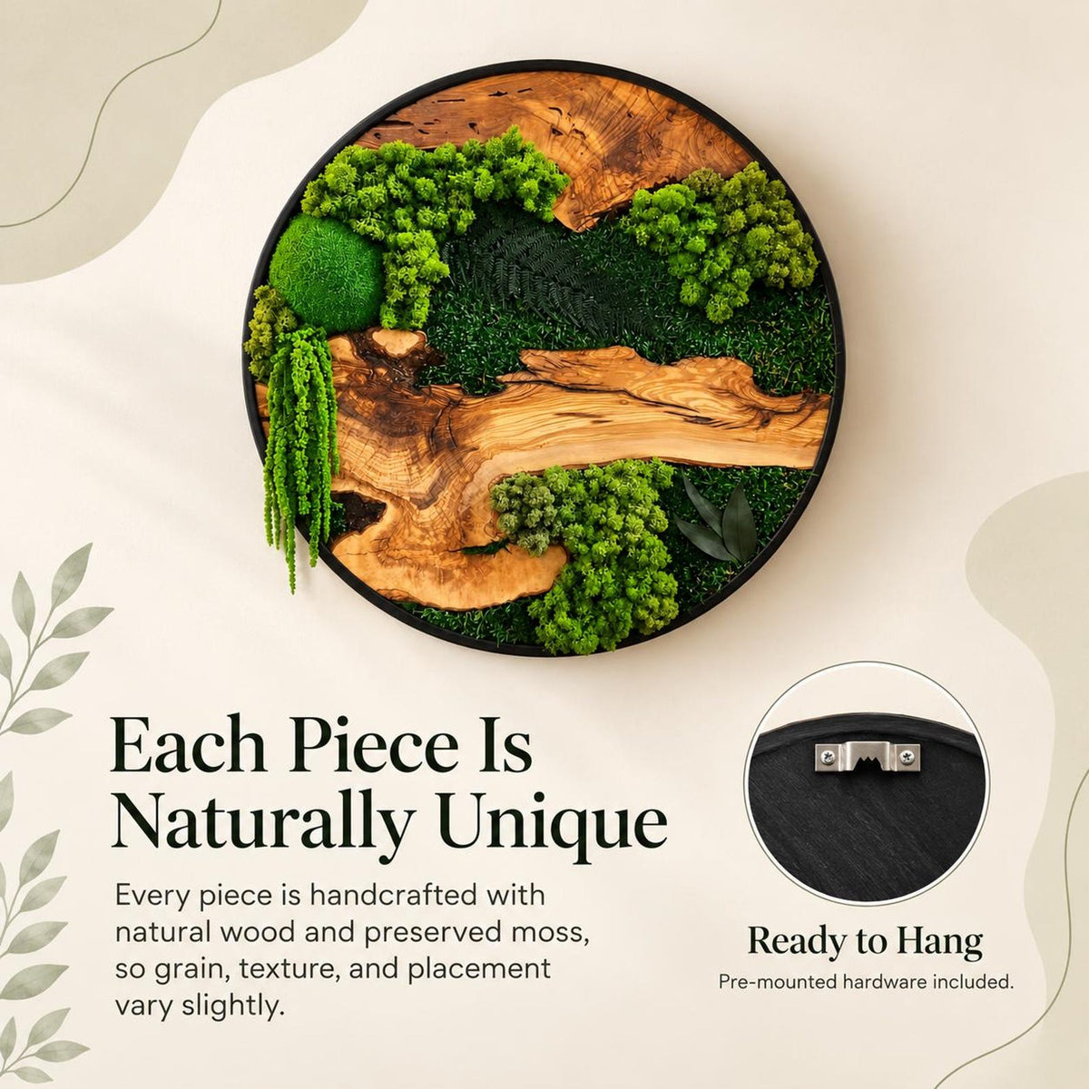 A circular wall art piece featuring a black frame, natural wood grain, and various shades of preserved green moss. The design includes a round moss ball, hanging moss strands, and a metal sawtooth hanger on the back for mounting.