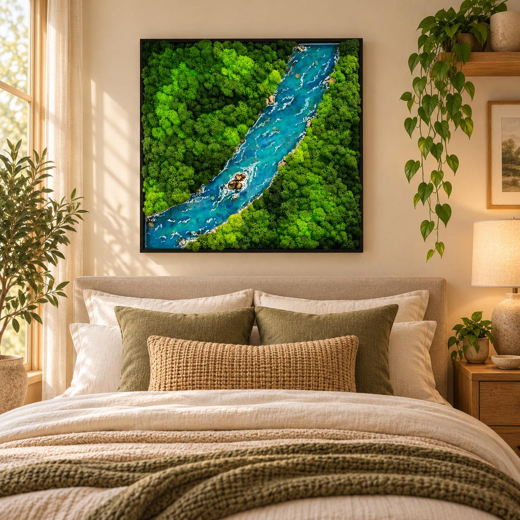 A square wall art piece featuring a preserved moss landscape with a central winding river made of blue resin. The artwork displays dense, vibrant green moss textures surrounding a flowing water effect with small rocky details.