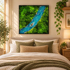 A square wall art piece featuring a preserved moss landscape with a central winding river made of blue resin. The artwork displays dense, vibrant green moss textures surrounding a flowing water effect with small rocky details.