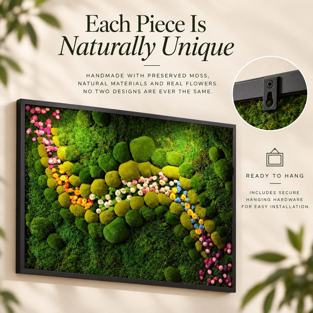 A rectangular wall art piece featuring preserved green moss and small colorful flowers in a black frame. Text reads: Each Piece Is Naturally Unique, Handmade with preserved moss, natural materials and real flowers. No two designs are ever the same. Ready to hang includes secure hanging hardware for easy installation.