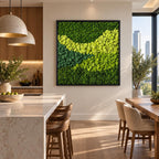 A square wall art piece featuring a dense arrangement of preserved moss in varying shades of green, ranging from deep forest green to bright lime, contained within a thin black frame, creating a textured, organic, and layered appearance.