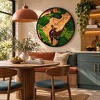A circular wall art piece featuring a natural wood slice centerpiece surrounded by vibrant green preserved moss. The artwork is encased in a thin black frame and mounted on a wall above a dining area with a wooden table and chairs.