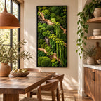 A rectangular wall art piece featuring a dense arrangement of preserved green mosses and light-colored driftwood branches encased in a thin black frame, displaying various textures and shades of vibrant forest and lime green foliage.