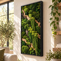 A rectangular wall art piece featuring a black frame filled with preserved green moss in various shades and textures, accented by light brown driftwood branches that extend diagonally across the composition.