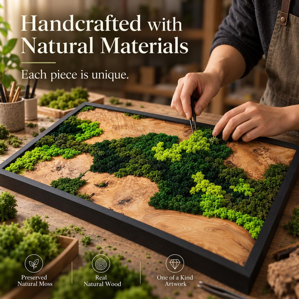 A rectangular wall art piece featuring a natural wood base with preserved moss in various shades of green, enclosed in a black frame. The text reads: Handcrafted with Natural Materials, Each piece is unique, Preserved Natural Moss, Real Natural Wood, One of a Kind Artwork.