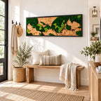 A rectangular wall art piece featuring preserved green moss arranged on a natural wood grain background, framed in a thin black border. The moss displays varying shades of dark and light green, creating a textured, organic landscape.